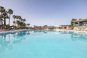 A large outdoor swimming pool with lounge chairs and palm trees. - Caybeach Princess (San Bartolomé de Tirajana)