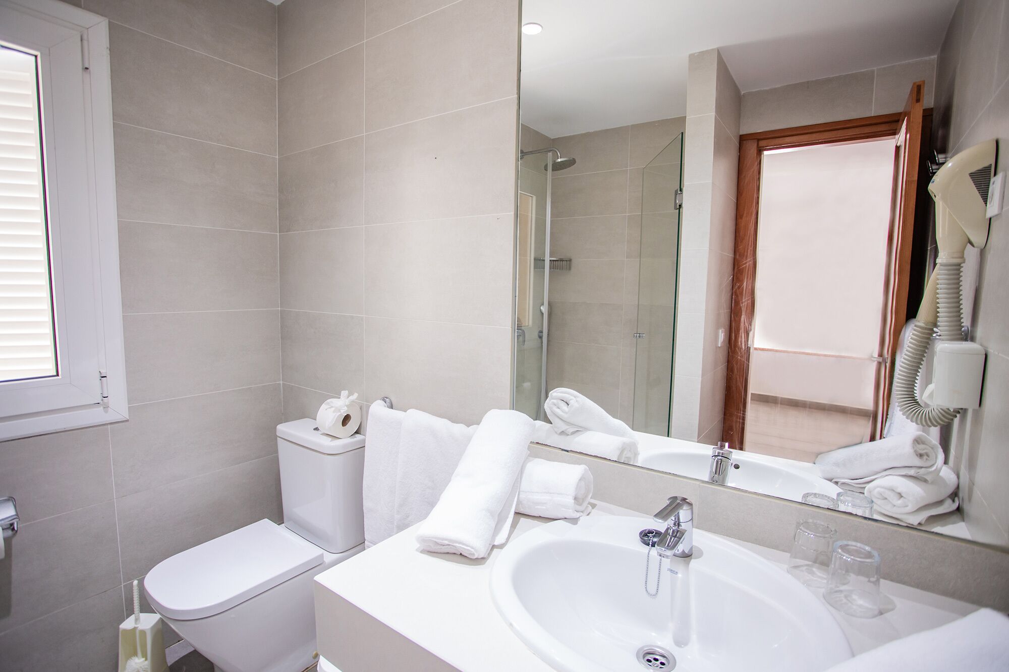 Une salle de bain moderne équipée de toilettes, d’un lavabo et d’une douche.