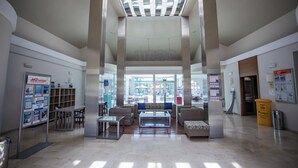 A spacious lobby with a high ceiling, large windows, and a central seating area with sofas and a coffee table. - Caybeach Princess (San Bartolomé de Tirajana)