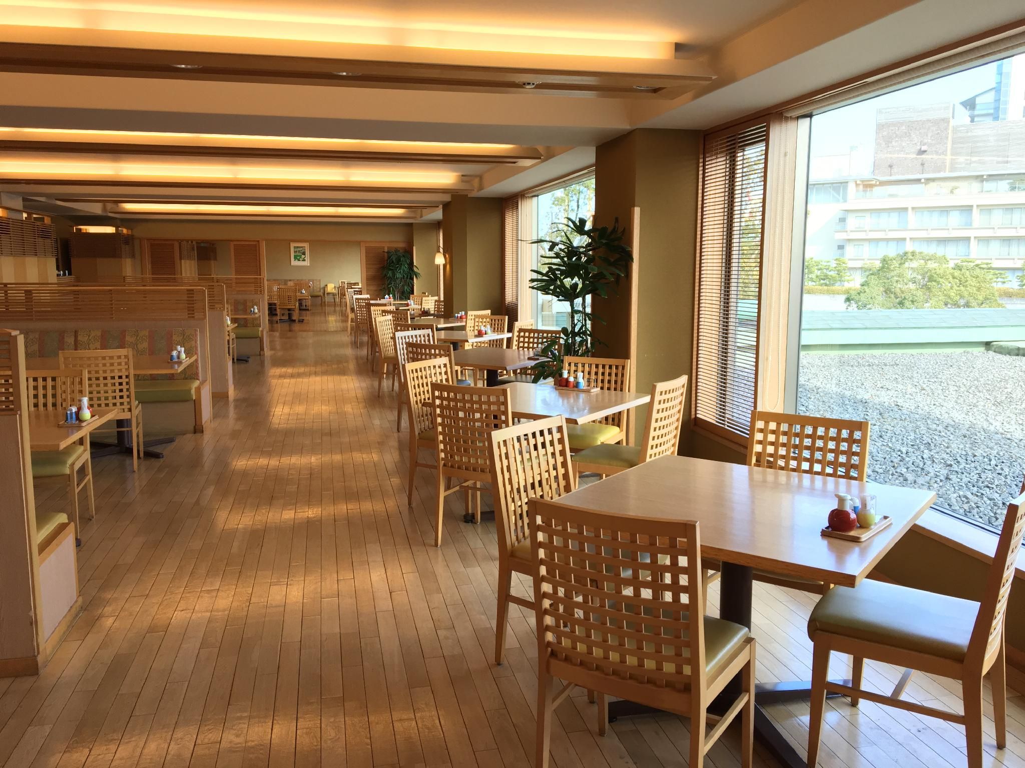 A restaurant with wooden furniture, a tiled floor, and large windows.