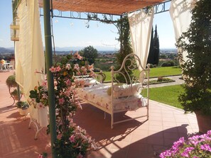 A bed with a canopy in a garden setting. - Il Campano (Pescia)