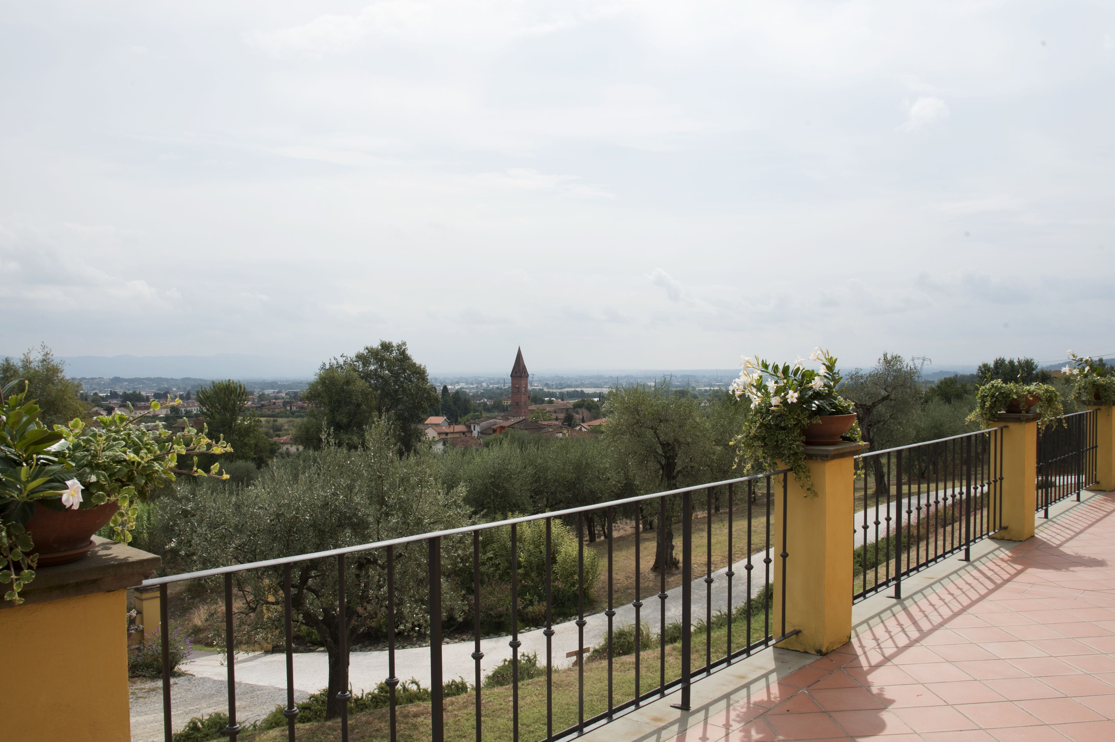 Un balcón con vistas a un pueblo, incluyendo una torre.