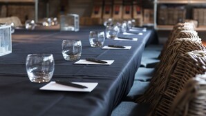 A long table set with glasses and napkins, with baskets and bottles in the background. - The Castle Inn (Harrogate)