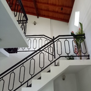 Una escalera con barandillas negras y paredes blancas.