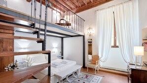 Une chambre avec un lit superposé, un bureau, une chaise et une fenêtre avec des rideaux.