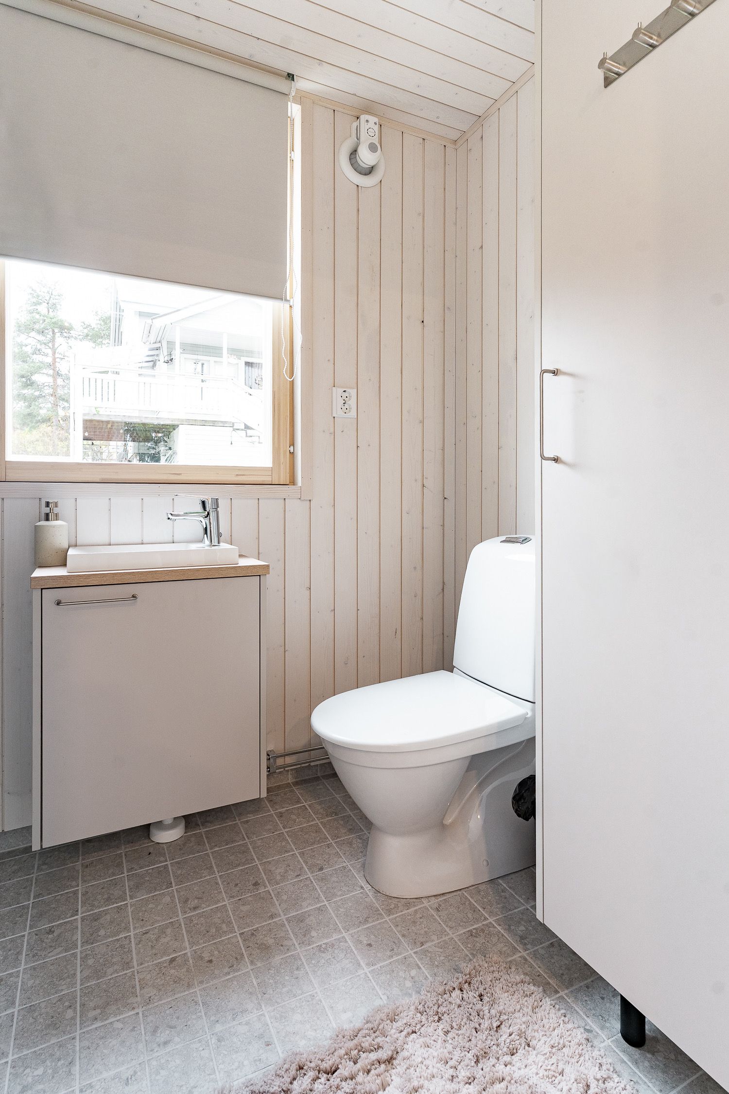 Un baño pequeño y funcional con inodoro, lavabo y ventana.