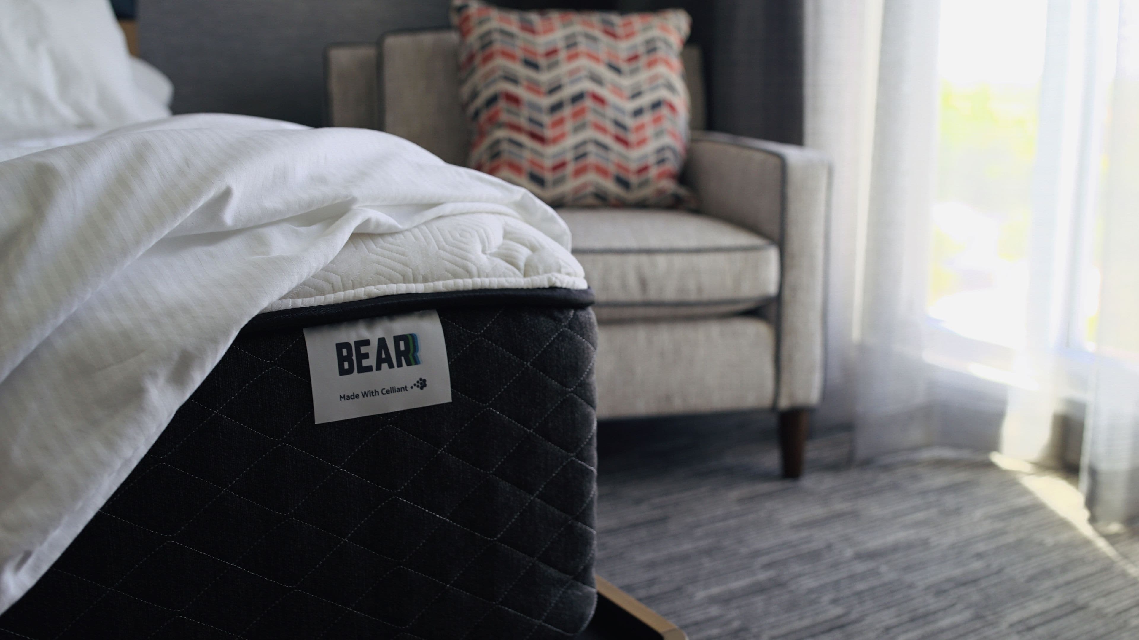 En seng med en quiltet madras med teksten "BEAR" og en etiket, der angiver, at den er lavet med Celliant.