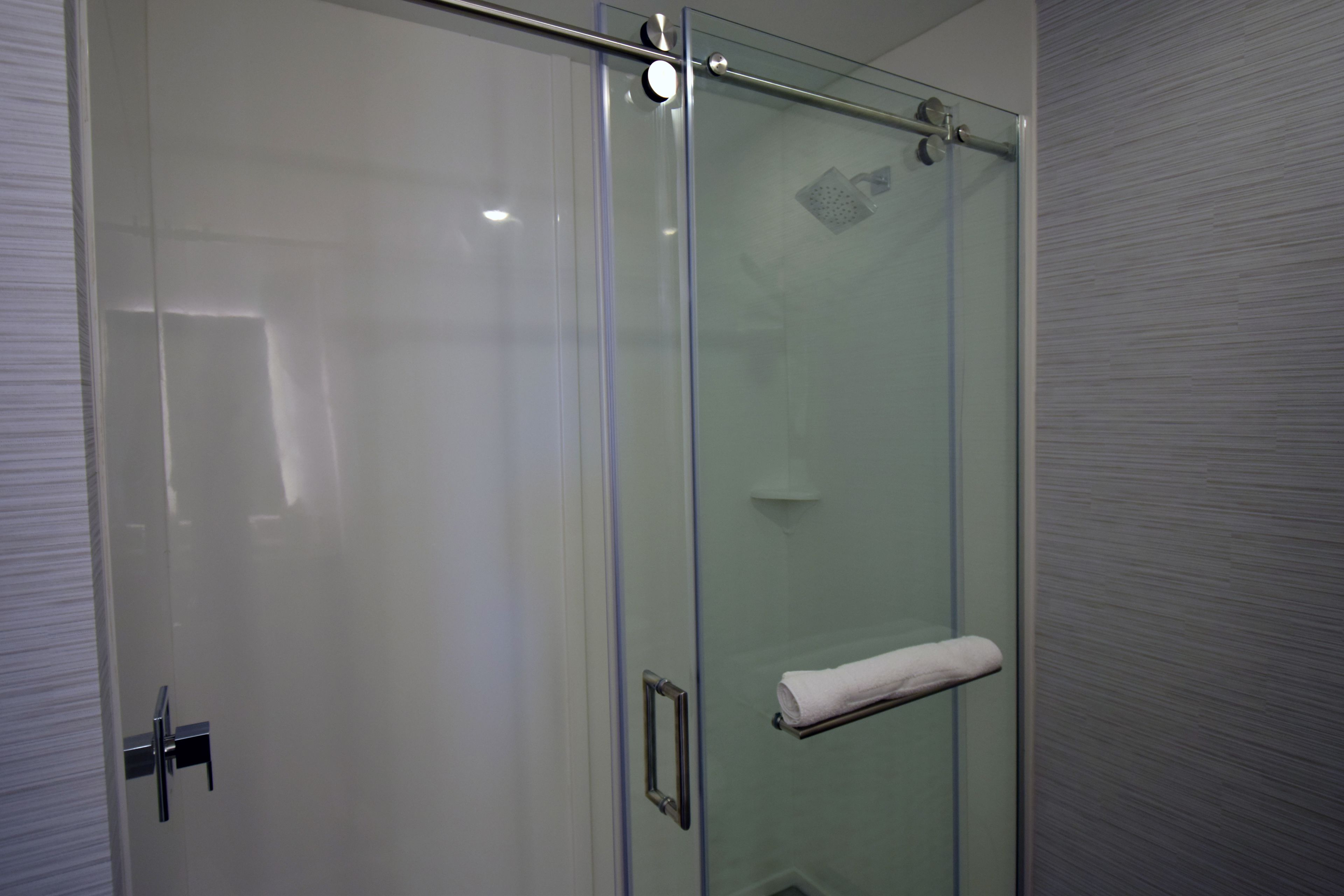 Une cabine de douche fermée par des parois en verre, dotée d’un porte-serviettes et d’une poignée de porte.