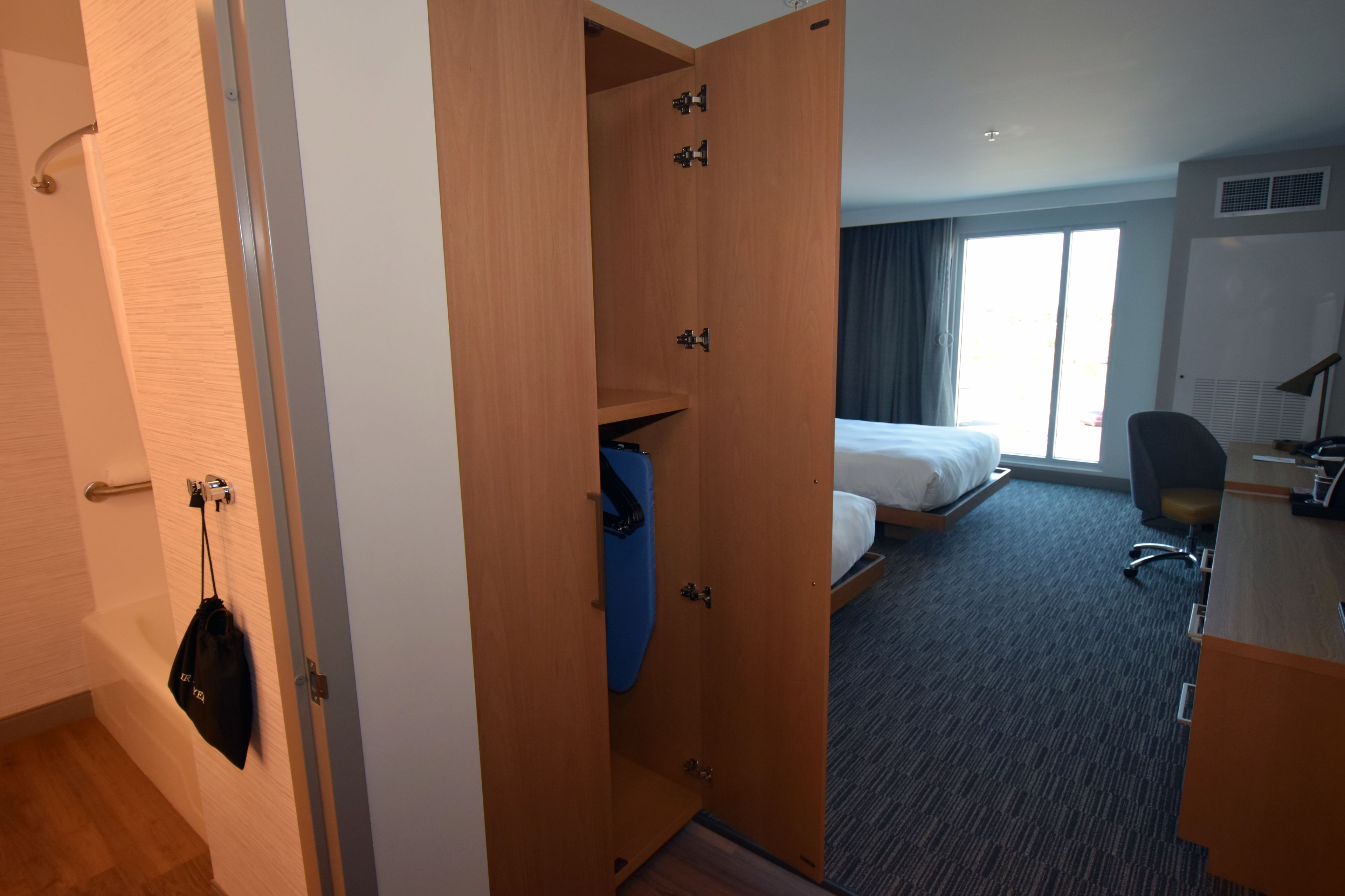 Hotellihuone, jossa on sänky, työpöytä, tuoli, vaatekaappi ja kylpyhuone.