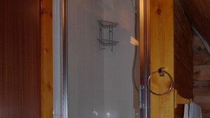 A wooden cabin with a glass-enclosed shower area, a towel hanging on a hook, and a wooden door. - Steading Holidays - Comraich (Acharacle)