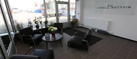 A hotel lobby with a view of the parking lot, a reception desk, and a sign reading "HOTELL RÄTTVIK".