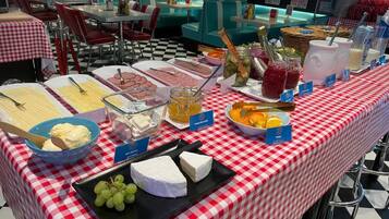 Una mesa de buffet con distintos alimentos y un mantel a cuadros.