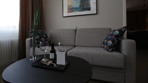 A modern living room with a grey sofa, a black coffee table, and a framed picture on the wall. - Hotell Rättvik (Rattvik)