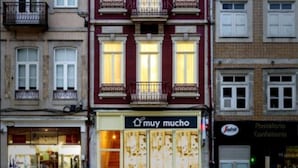 A multi-story building with a storefront labeled "muy mucho." - Mercado dos Poetas (Porto)
