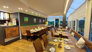 Un restaurante con cabinas y mesas, una barra y obras de arte en las paredes.