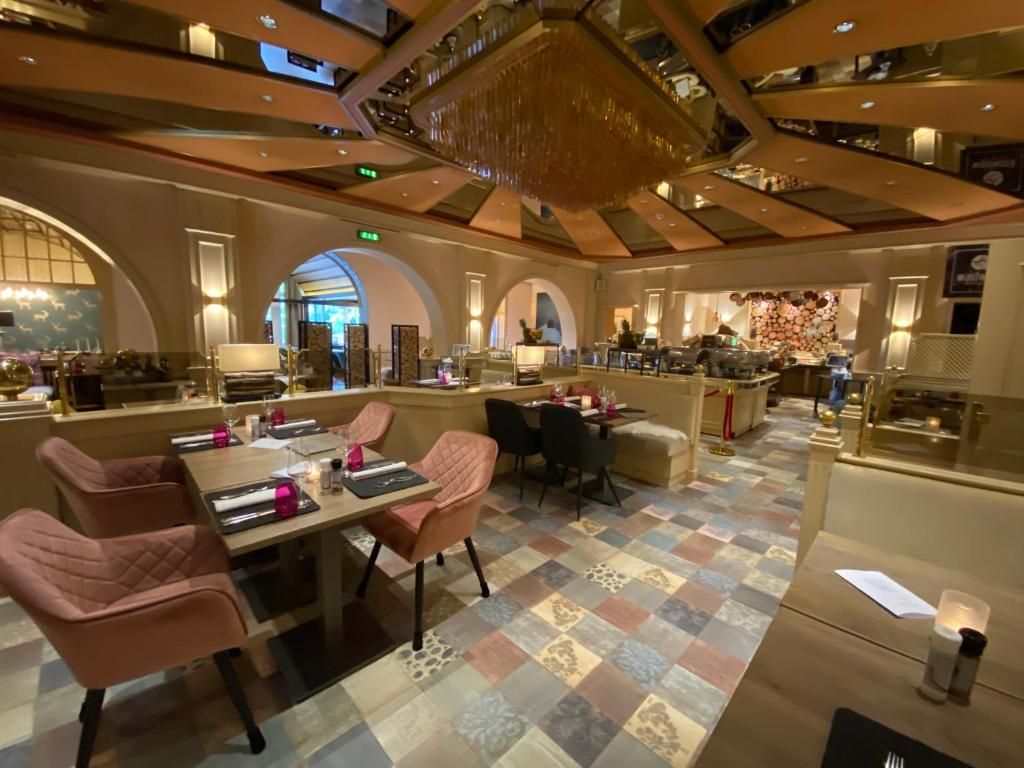 Un vestíbulo de hotel con mostrador de recepción, zona de estar y un techo decorativo.