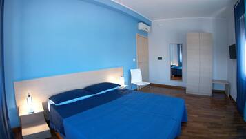 Una camera da letto con un letto grande, comodini, una sedia, un armadio e uno specchio.