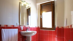 A bathroom with a white sink, a toilet, and a mirror with lights. - B&B Santa Caterina (Reggio Calabria)