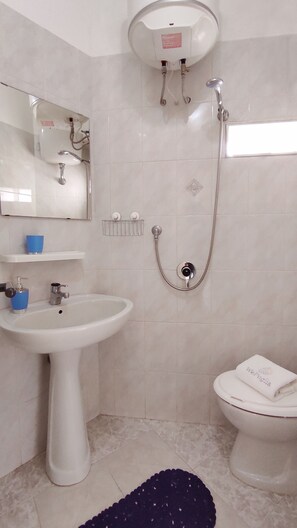 A bathroom with a pedestal sink, a handheld showerhead, a toilet, and a mirror. - Sogno Blu (Polignano a Mare)