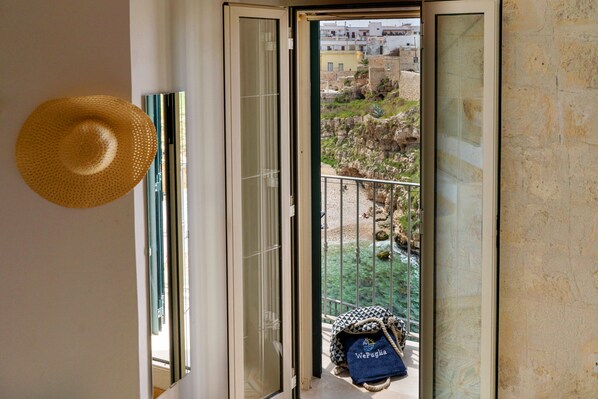 A balcony with a view of a rocky landscape and buildings. - Sogno Blu (Polignano a Mare)