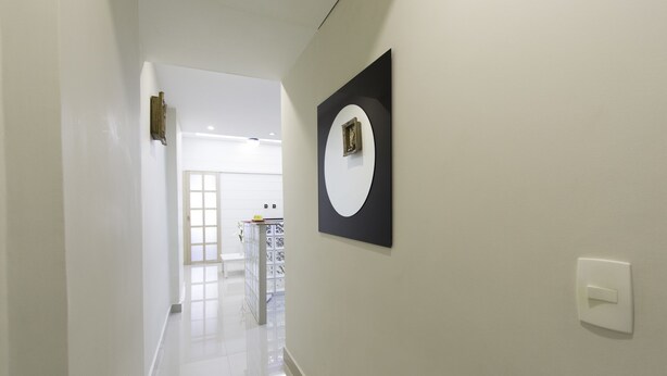 A hallway with a white wall, a framed picture, and a light switch. - LineRio Copacabana Luxury Residence 161 (Rio de Janeiro)