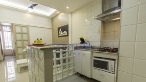 A modern kitchen with white cabinets, a built-in microwave, and a gas stove. - LineRio Copacabana Luxury Residence 161 (Rio de Janeiro)