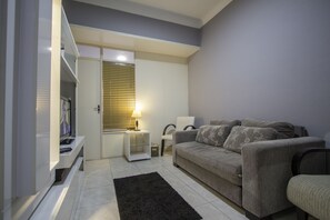 A living room with a sofa, a TV, a lamp, and a window with blinds. - LineRio Copacabana Family Residence 188 (Rio de Janeiro)