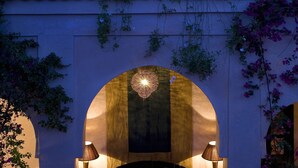 A cozy bedroom with a bed, two bedside lamps, and an ornate ceiling light. - Riad Meriem (Marrakech)