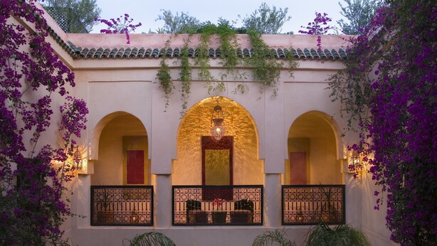 A building with three arched balconies, each with a small table and chairs. - Riad Meriem (Marrakech)