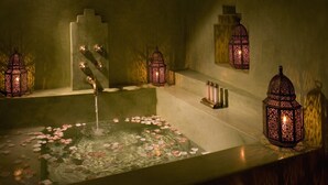 A serene indoor pool with rose petals floating on the water, surrounded by ornate lanterns. - Riad Meriem (Marrakech)