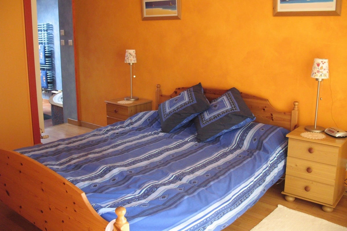A bedroom with a bed, two bedside tables, and a nightstand.