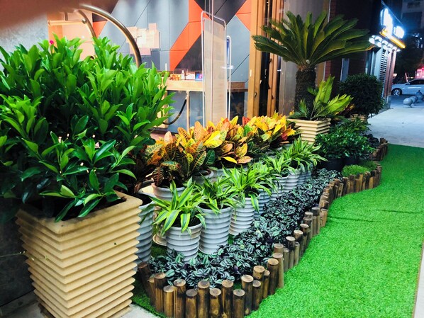 A row of potted plants with a variety of foliage, arranged in a tiered planter design. - Holiday Inn Express Chengdu Tianhe by IHG (Chengdu)