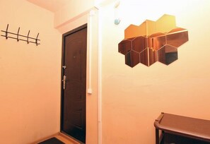 Cozy space with an entrance, coat rack, and unique wall decoration.