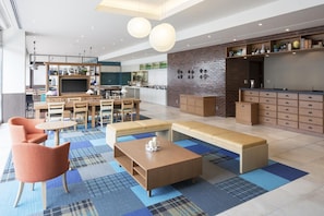 Un interno moderno con zona pranzo, cucina e angolo salotto.