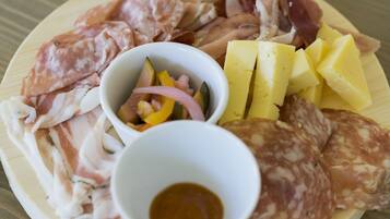 Un piatto con salumi, formaggi e verdure sottaceto.