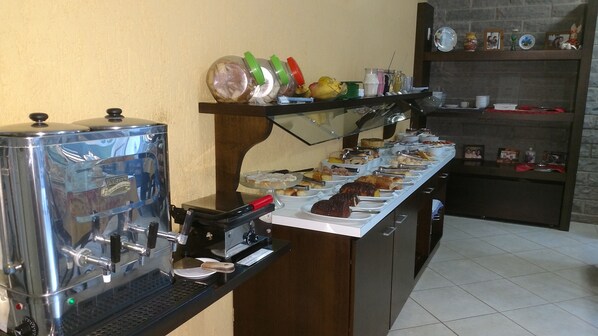A buffet setup with a coffee machine and various food items.