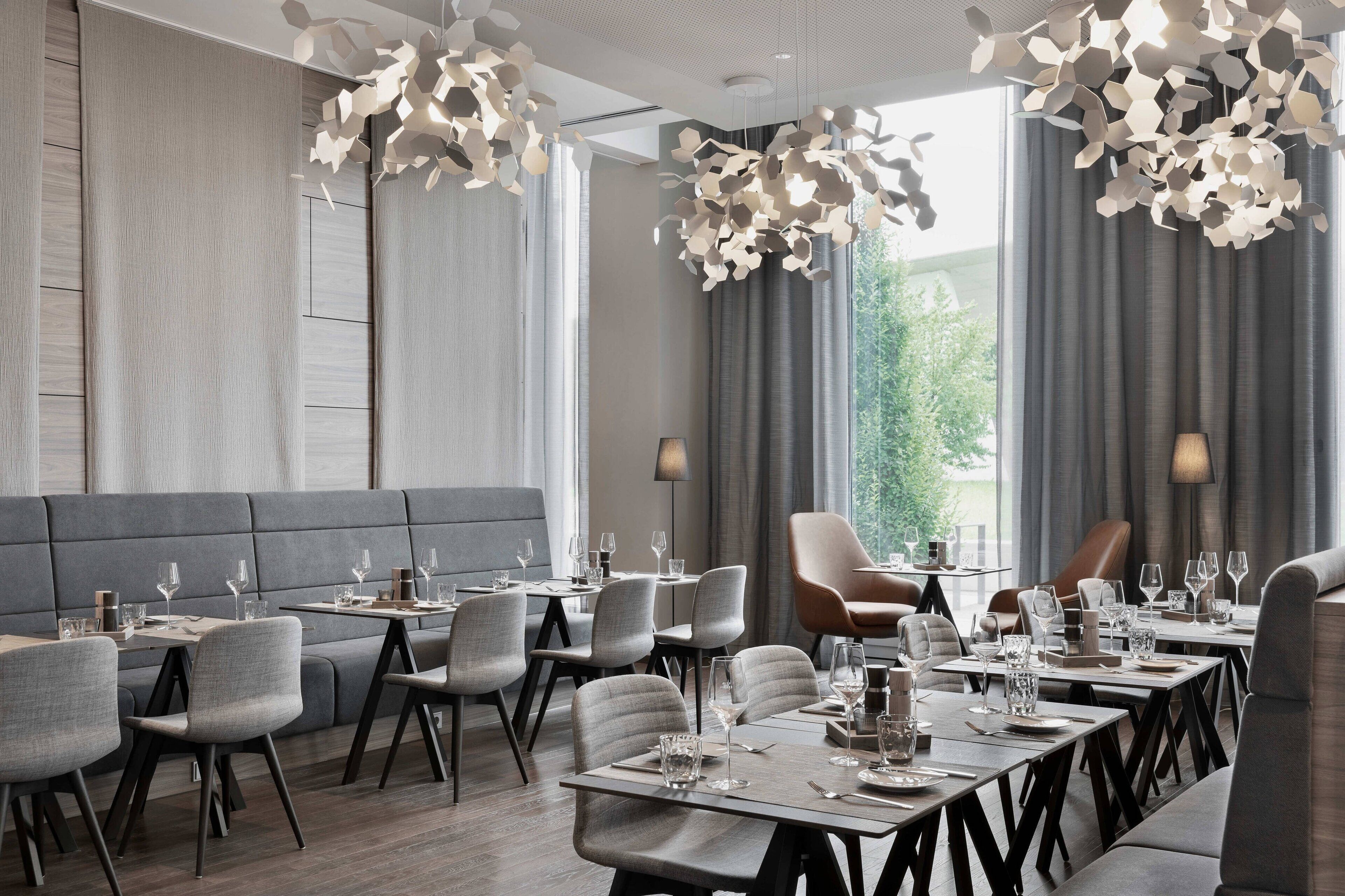 Un restaurant moderne doté d’une grande salle à manger, de nombreuses tables et de chaises.