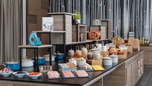 A buffet setup with various food items and kitchenware.