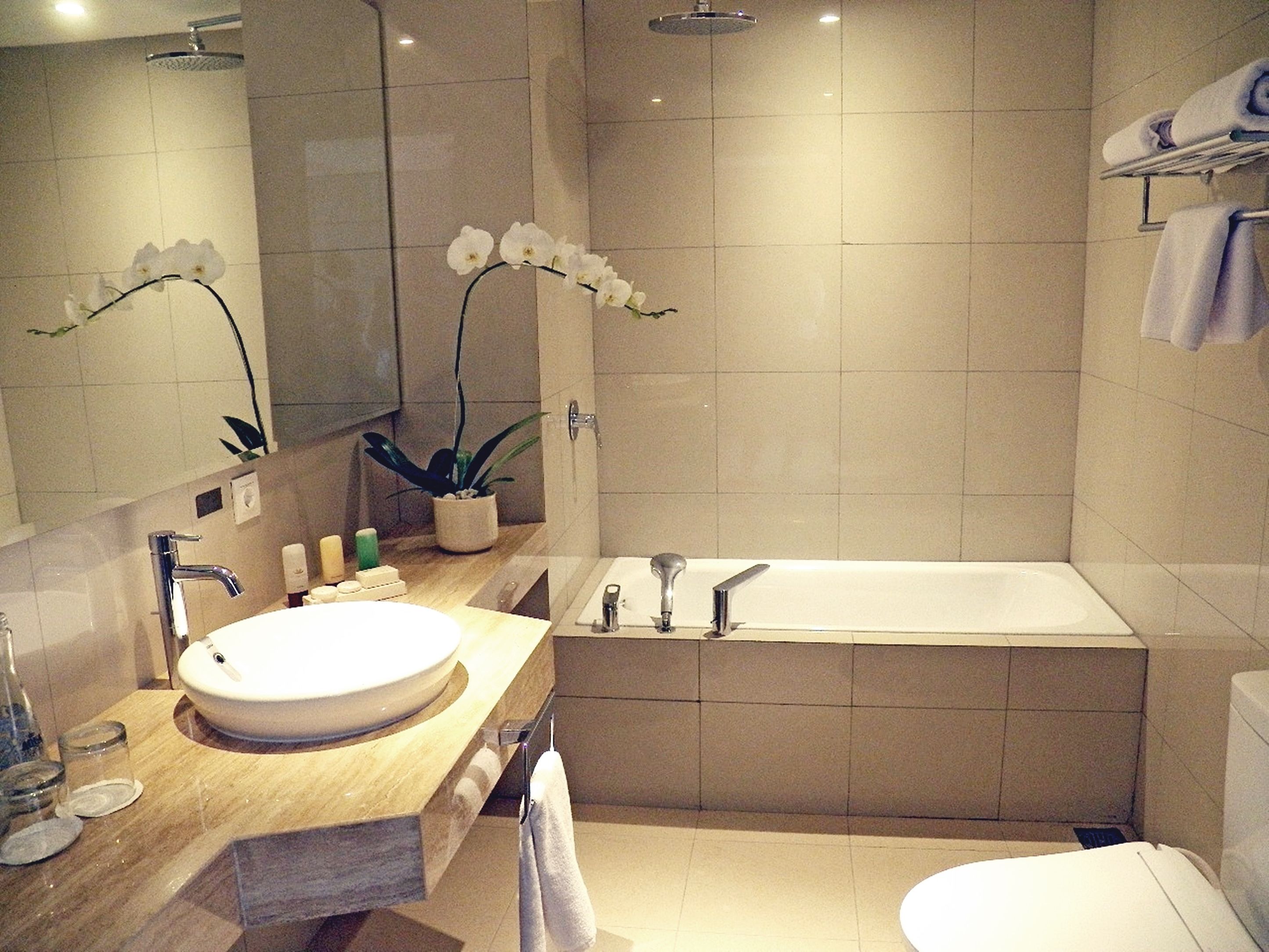 Ein modernes Badezimmer mit einem großen Waschbecken, einer Badewanne und einem Spiegel.