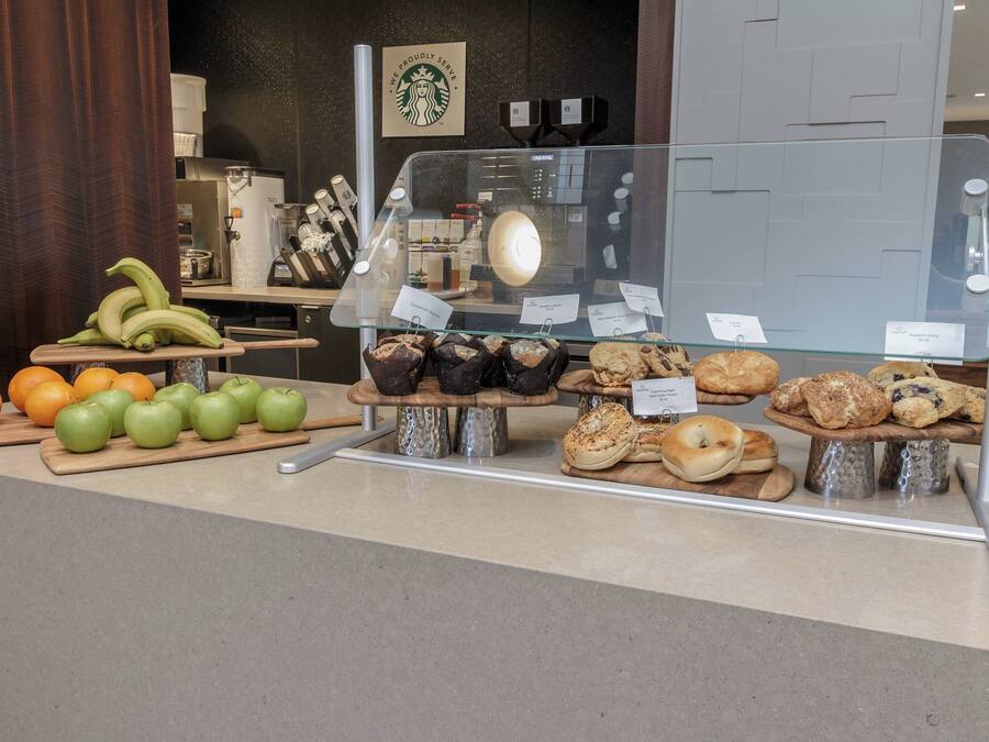 A bakery display with various baked goods and fresh produce.