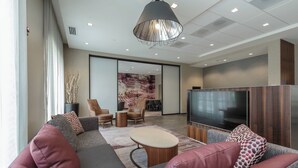 Una sala de estar moderna con un sofá, sillones, una mesa de centro y un televisor.