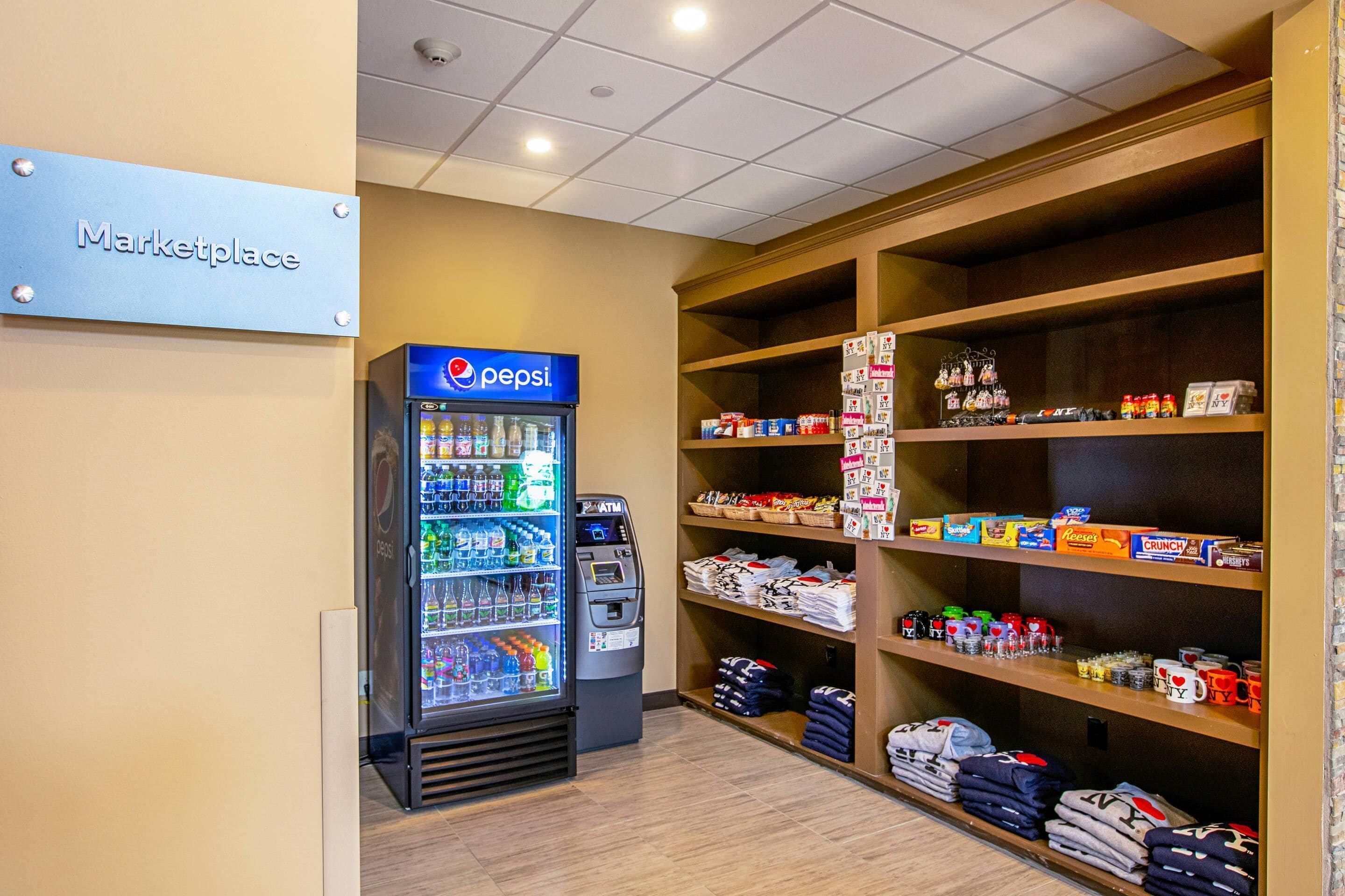 A marketplace area with a Pepsi refrigerator and shelves stocked with snacks and merchandise.