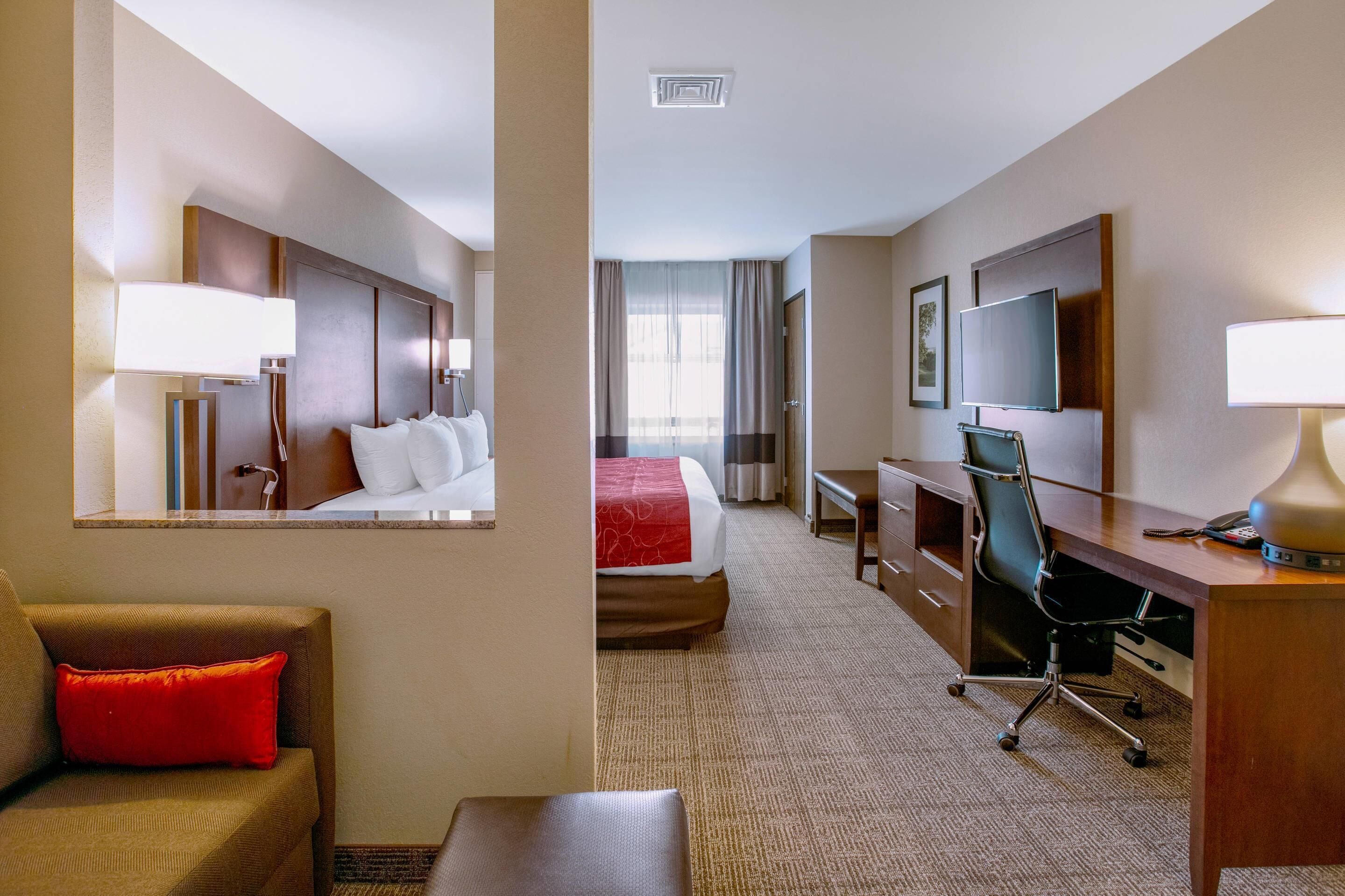 Une chambre d’hôtel équipée d’un lit, d’un bureau, d’une chaise et d’un téléviseur.