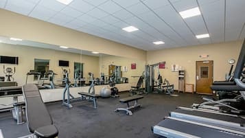 A gym with treadmills, weight machines, and benches.