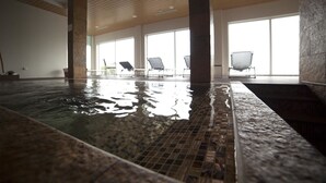 An indoor swimming pool with clear water, tiled floor, and several lounge chairs. - Hotel Rural Quinta da Conchada (Penacova)