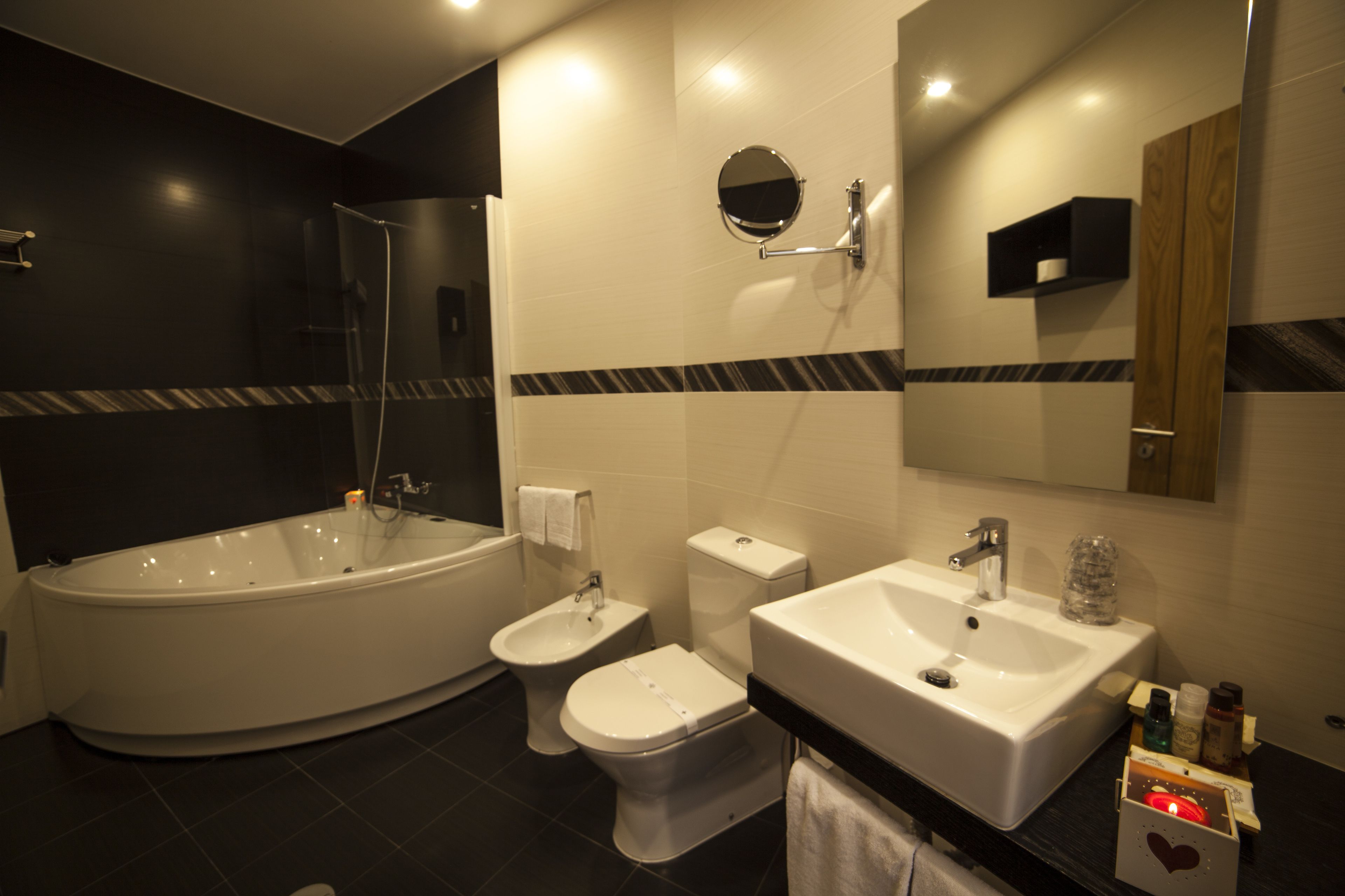 Un baño moderno con una bañera independiente, un inodoro separado y un lavamanos.