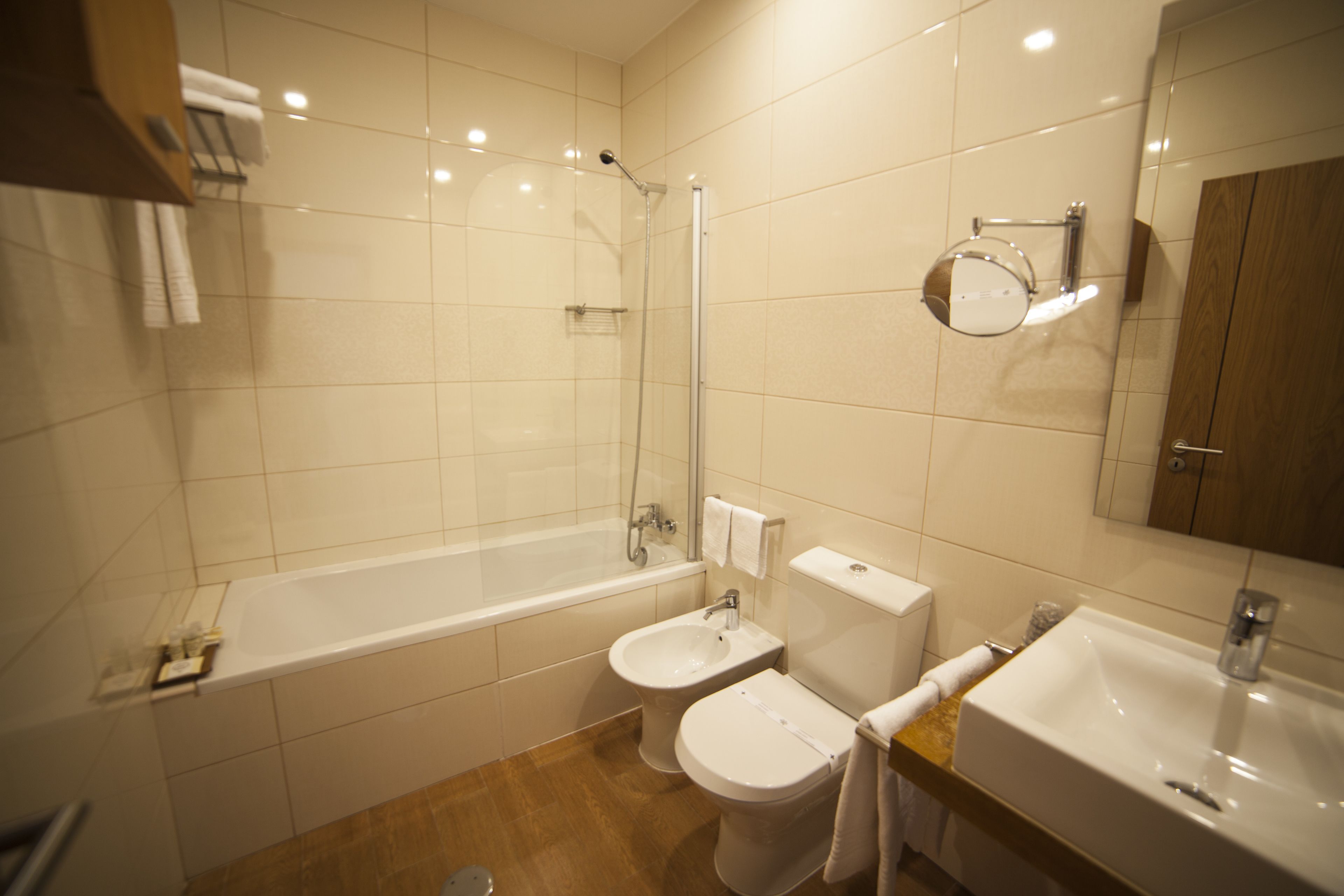 A modern bathroom with a bathtub, a sink, a toilet, and a bidet.
