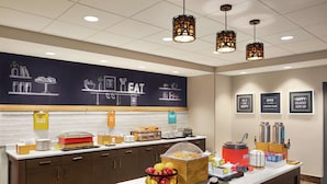 A breakfast bar with a chalkboard menu, a fruit basket, and various breakfast items. - Hampton Inn & Suites Overland Park South (Overland Park)