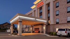 A Hampton Inn & Suites with a covered entrance, brick facade, and a 140' clearance sign. - Hampton Inn & Suites Overland Park South (Overland Park)