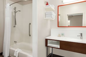 A bathroom with a bathtub, a shower, a sink, and a mirror. - Hampton Inn & Suites Overland Park South (Overland Park)